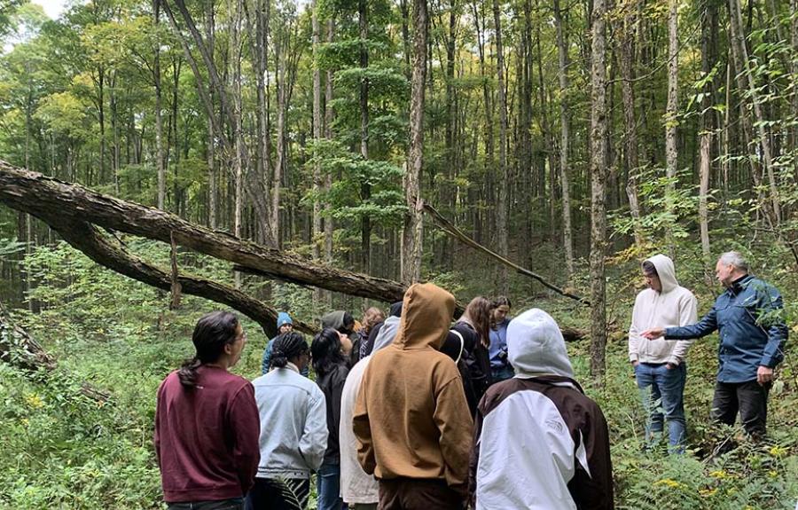 group of students in woods listening to instructor