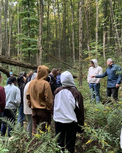 group of students in woods listening to instructor
